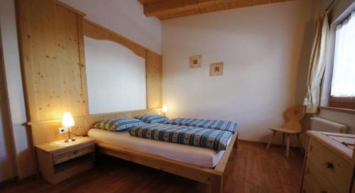 a bedroom with a bed in a room with a window at Apartments Antersi Silvia in San Vigilio Di Marebbe