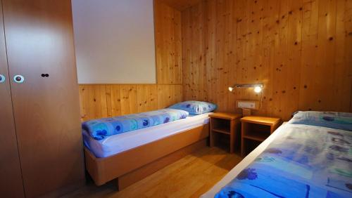 サン・ヴィジリオ・ディ・マレッベにあるApartments Antersi Luisのベッド2台 木製の壁の部屋