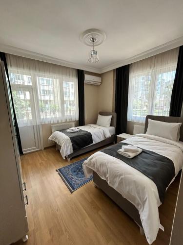 a bedroom with two beds and two windows at anka suiteapart in Bostancı