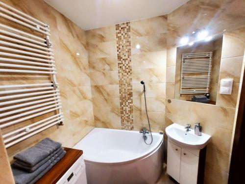 łazienka z wanną, umywalką i toaletą w obiekcie Apartament ORANGE Warmia Towers w Olsztynie