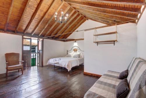 um quarto com uma cama e um sofá num quarto em Casa Tajinaste em Vilaflor