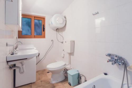y baño con aseo, lavabo y espejo. en Beautiful Cottage over-viewing Samos bay., en Samos