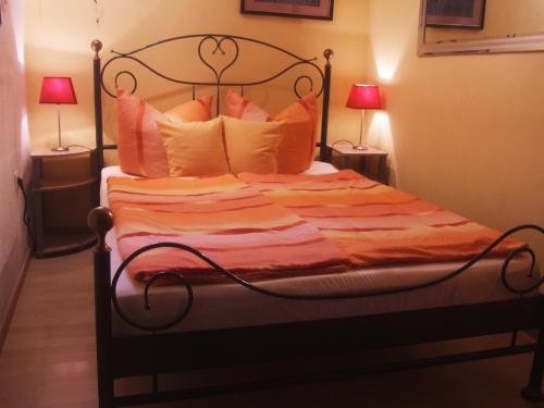 een slaapkamer met een bed met kussens en 2 lampen bij Lindenbornhof in Edesheim