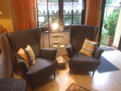 2 stoelen en een tafel in een kamer met ramen bij Lindenbornhof in Edesheim