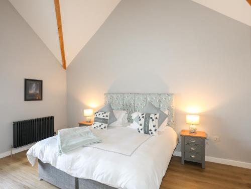 a bedroom with a large white bed with two lamps at The Forge in Holyhead