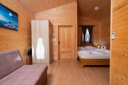 a small bedroom with a bed and a wooden wall at Sunny Garden in Ulcinj