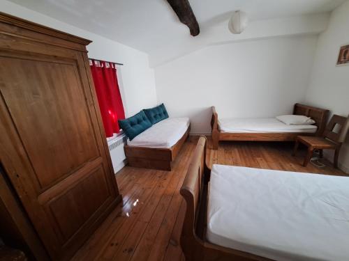 a small room with two beds and a cabinet at Appart-Hôtel Résidence Maloc in Malaucène