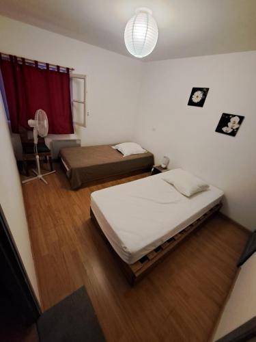 a bedroom with two beds and a red curtain at Appart-Hôtel Résidence Maloc in Malaucène