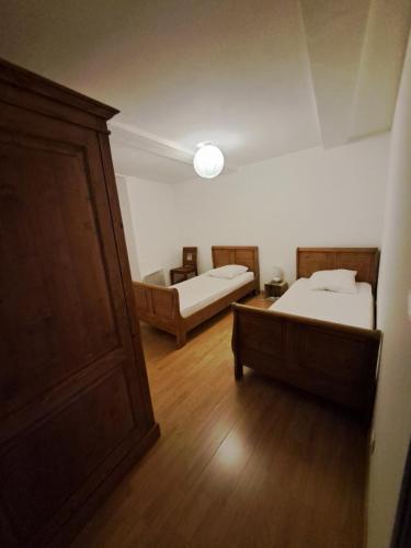 a room with two beds and a wooden floor at Appart-Hôtel Résidence Maloc in Malaucène