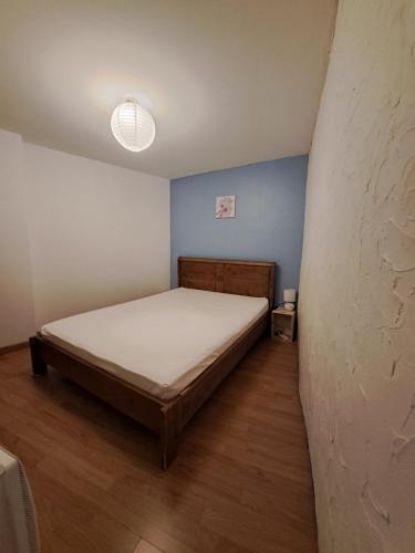 a bedroom with a bed in a room with blue walls at Appart-Hôtel Résidence Maloc in Malaucène