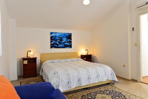 a bedroom with a bed and a painting on the wall at Villa Kuljis in Komiža