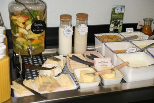 a table topped with cheese and bottles of milk at ibis Saint-Lô in Saint Lo