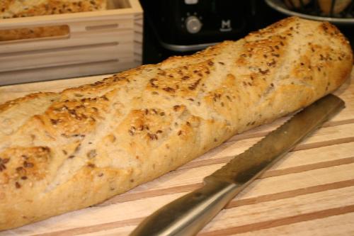 a piece of bread on a cutting board with a knife at ibis Saint-Lô in Saint Lo