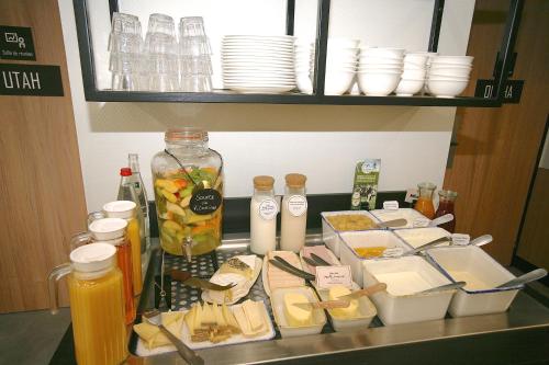 a counter with cheese and other food items on it at ibis Saint-Lô in Saint Lo
