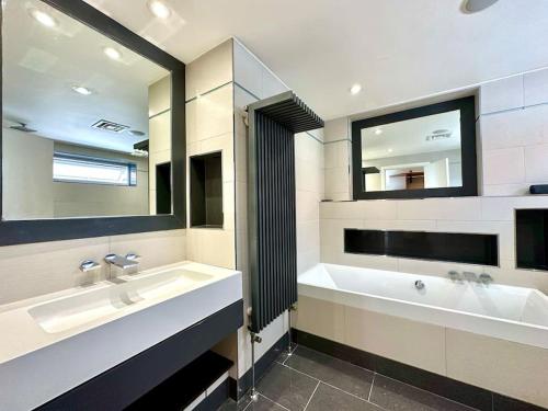 a bathroom with two sinks and a large mirror at Stunning Panoramic Sea View Beach Location - Sleeps up to 4 People - Free Parking - The Best Beach! - Great Location - Fast WiFi - Smart TV - Newly decorated - sleeps up to 4! Close to Bournemouth & Poole Town Centre & Sandbanks in Bournemouth