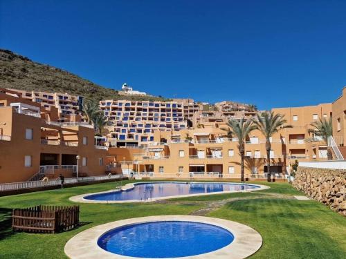 un complejo con piscina frente a un edificio en LyriosHomes Marina de la Torre Beach, en Mojácar