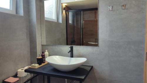 a bathroom with a bowl sink and a mirror at Bohemian Home in Skopje