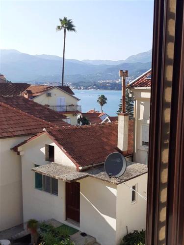 a view of a city with buildings and a palm tree at Guesthouse Gavrilović 28 A in Njivice