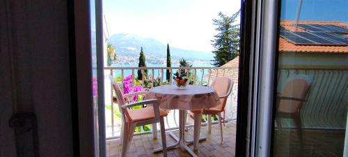 una mesa y sillas sentadas en un balcón en Guesthouse Gavrilović 28 A en Njivice