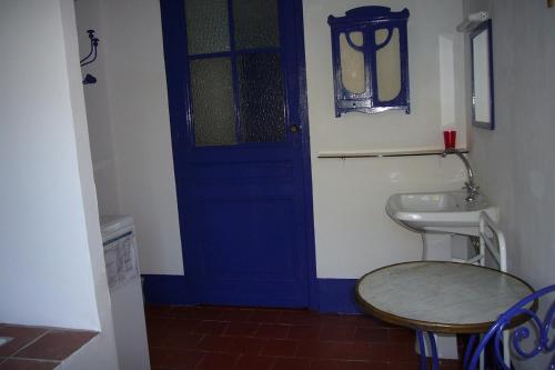 a bathroom with a blue door and a sink at L Oustal maison vigneronne in Villeneuve-lès-Béziers