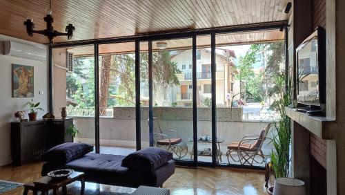 uma sala de estar com um sofá e uma varanda em Bohemian Home em Skopje