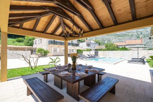 a wooden table and benches on a patio at Villa MarLea in Dubrovnik