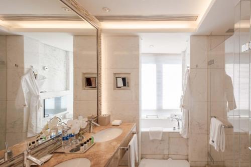 a bathroom with two sinks and a shower and a mirror at The Westin Nanjing Xuanwu Lake in Nanjing