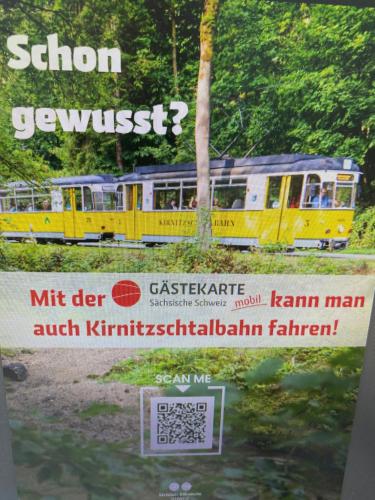 un cartel con un tren amarillo en las vías en Ferienwohnung Zimmermann, en Bad Schandau