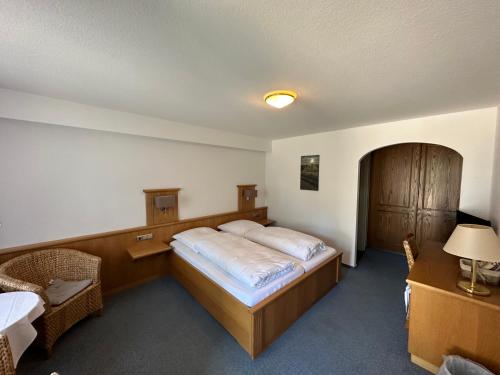a bedroom with a bed and a table and a chair at Gasthof Menke in Niederhaverbeck