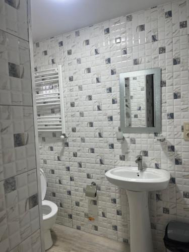 a bathroom with a sink and a toilet and a mirror at Guest House in Batumi