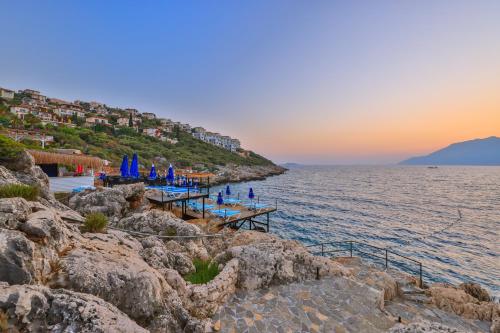 a view of the ocean and a dock with umbrellas at Arpia Hotel in Kas
