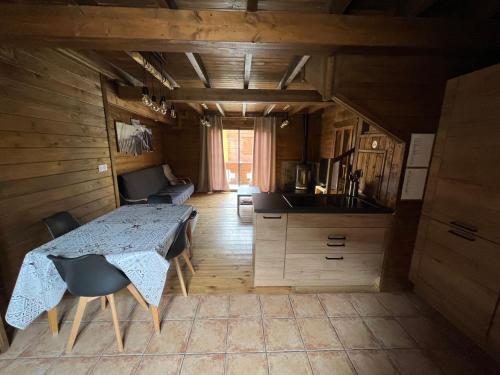 a kitchen with a table and chairs in a room at Chalet 6A dans les Pyrénées proche d'Andorre in LʼHospitalet-près-lʼAndorre