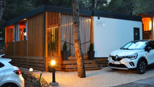 a small house with a car parked in front of it at Lucas Mobile Home - premium mobile home with terrace and patio in Drage