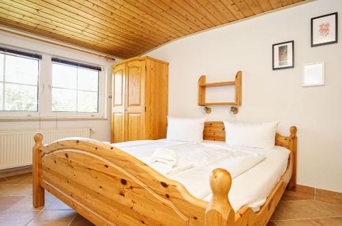 a bedroom with a wooden bed in a room at zentral aber ruhig, Terrasse mit viel Grün - strandnahes Ferienhaus Luki in Göhren