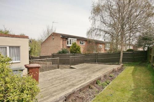 a wooden deck in a yard next to a house at Deluxe Double Room with Private Amenities in Banbury