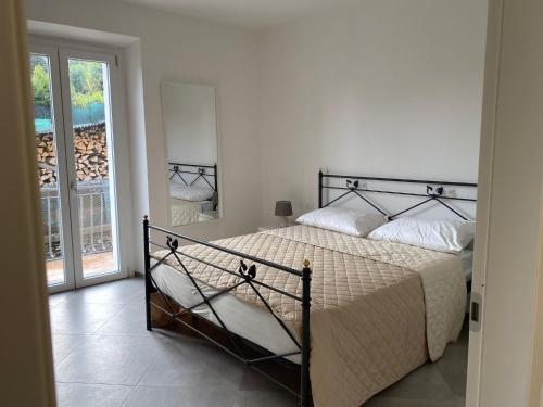 1 dormitorio con cama y ventana grande en Rosa dei Venti, en Baveno