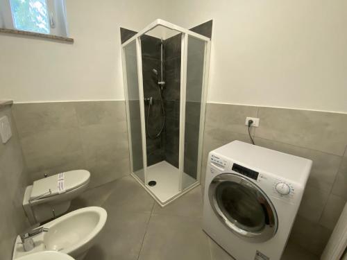 un bagno con doccia e lavatrice di Rosa dei Venti a Baveno