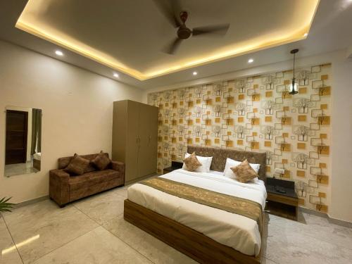 um quarto com uma cama grande e um sofá em The Empire Suites em Gurgaon