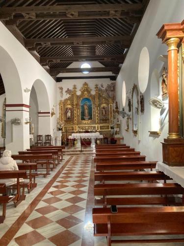 a church with wooden pews and a large altar at Apartamento La Fuente Alcaucin in Alcaucín