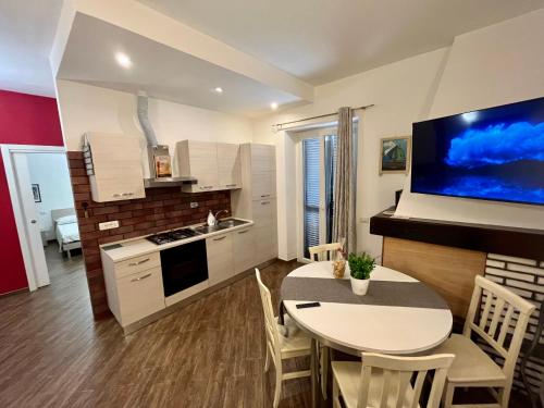 uma cozinha e sala de jantar com uma mesa e uma televisão em Casetta Teresa - Nice apartment em Trevignano Romano
