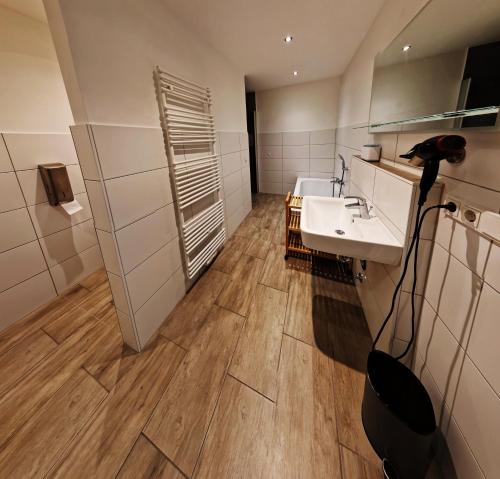 La salle de bains est pourvue d'un lavabo et d'un miroir. dans l'établissement Ferienwohnung Wiehl - Bielstein, à Wiehl
