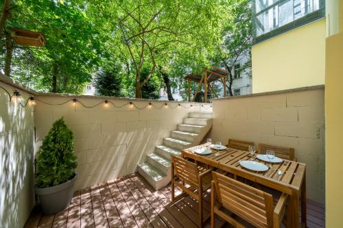 a patio with a table and chairs and a fence at Apart Hotel Zborovska in Prague