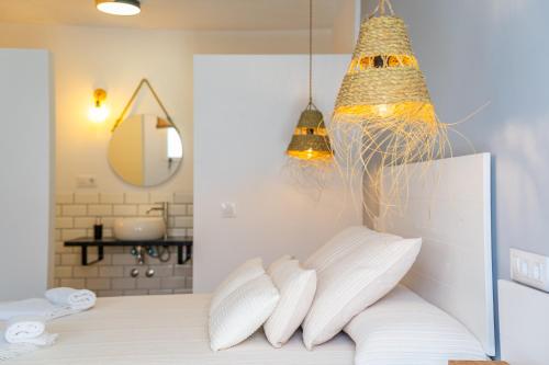 a room with a bed with white pillows and a mirror at Calas De Meca in Los Caños de Meca