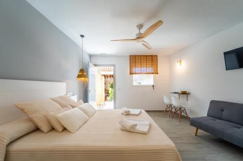 sypialnia z dużym łóżkiem i niebieskim krzesłem w obiekcie Calas De Meca w mieście Los Caños de Meca