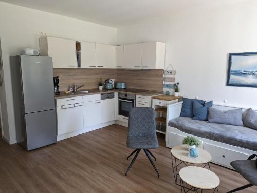 a small kitchen and living room with a couch at Fewo Freya in der Ostseeresidenz Gendarm in Wischuer