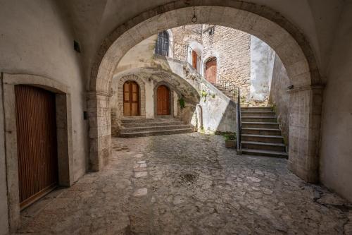 eine Gasse in einem alten Gebäude mit Tür und Treppe in der Unterkunft La torretta sul cortile in Monteroduni
