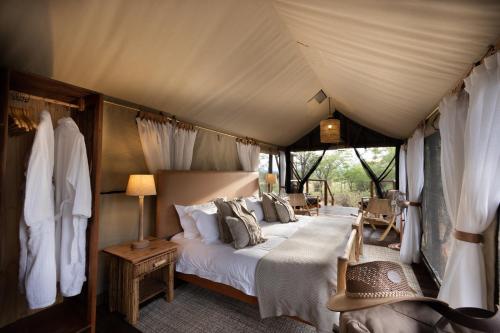 ein Schlafzimmer mit einem Bett in einem Zelt in der Unterkunft Kwafubesi Tented Safari Camp in Mabula