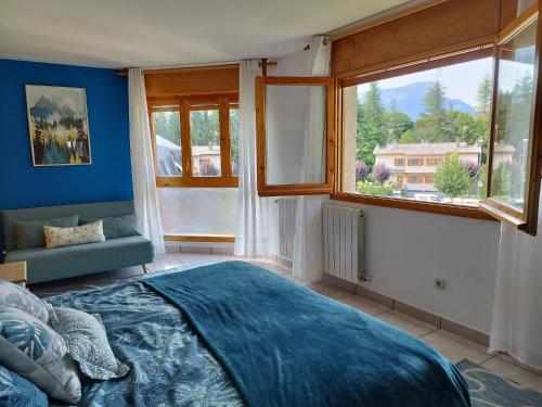 um quarto com paredes azuis, uma cama e janelas em Villa San Lure Jaca em Jaca