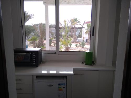 a kitchen with a window and a microwave at Ocean House sol y mar #1 in Rabil