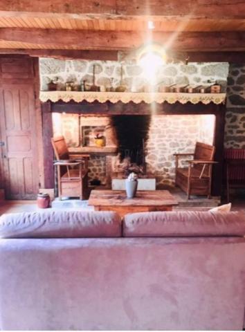 - un salon avec une cheminée et un canapé en face dans l'établissement La maisonnette, à Le Nayrac